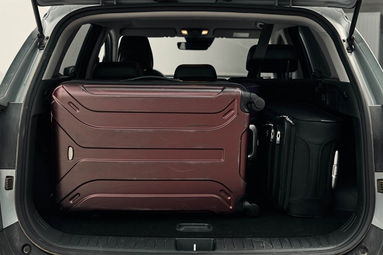 Kia Sportage with open trunk and luggage inside. 